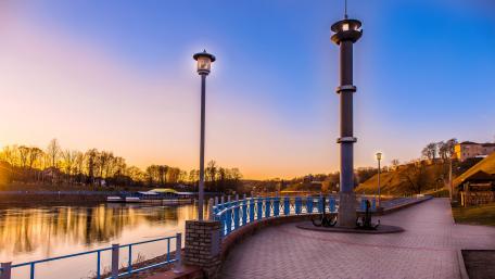 Tranquil Riverfront at Sunset Over Cityscape wallpaper