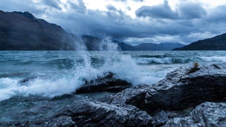 Dynamic Waves Against a Dramatic Cloudy Coastline wallpaper