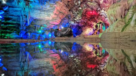 Vibrant Cave Reflection in Colorful Lights wallpaper