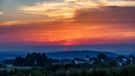 Vibrant Sunset Over Countryside Village wallpaper