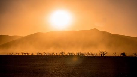 Golden Sunset Over Rolling Hills and Fields wallpaper