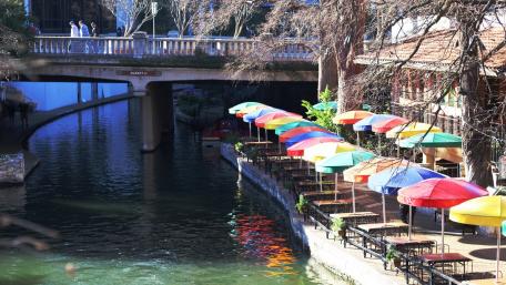 Charming Riverside Café with Colorful Umbrellas wallpaper