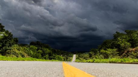Stormy Road Through Lush Nature Landscape wallpaper