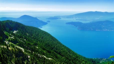 Majestic Coastal View of Lush Mountains and Serene Waters wallpaper