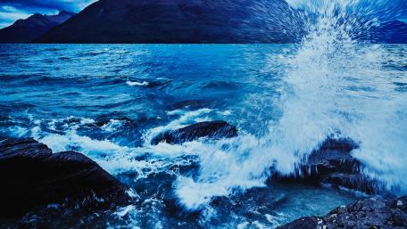 Majestic Waves Crashing Against Rocky Shoreline wallpaper