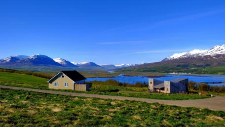 Serene Highland Cottage Amidst Majestic Mountains wallpaper