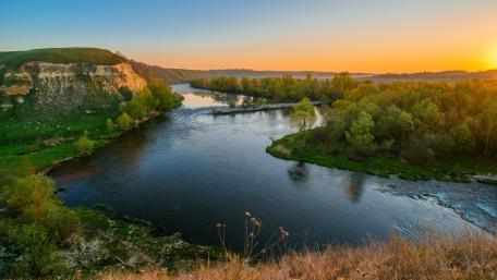 Tranquil River at Sunrise Overlooking Nature's Beauty wallpaper