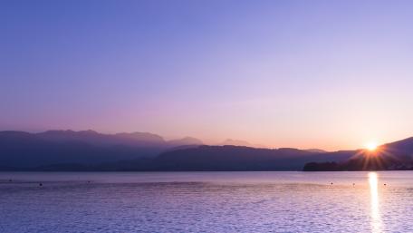 Serene Purple Sunset Over Tranquil Lake wallpaper