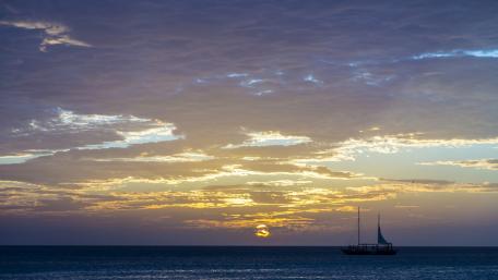 Tranquil Sailboat at Sunset Over the Sea wallpaper