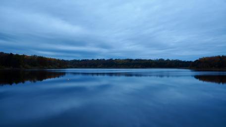 Serene Reflection of a Tranquil Lake at Dusk wallpaper