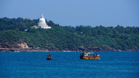 Serene Coastal Scene with Fishing Boat and Pagoda wallpaper