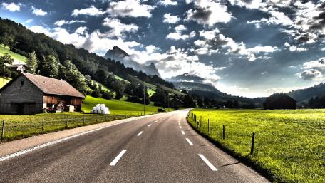 Scenic Alpine Drive Through Lush Meadows wallpaper