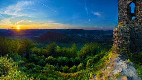 Ruins at Dawn with Blue Skies and Sunlit Hills wallpaper