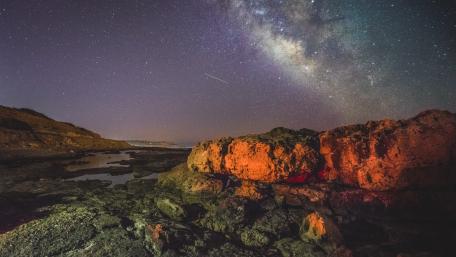Celestial Wonders Over Rocky Shores wallpaper