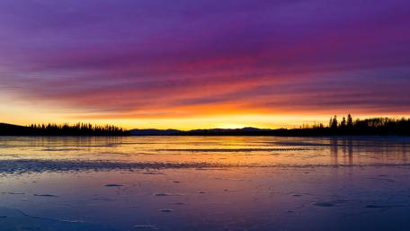 Serene Purple Sunset Over a Tranquil Lake wallpaper