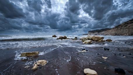 Dramatic Seaside Serenity Amidst Stormy Skies wallpaper