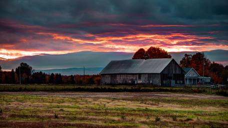 Serene Sunset Over a Tranquil Farmhouse wallpaper