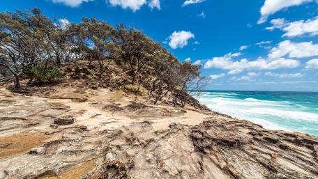 Serene Tropical Beach Landscape with Fluffy Clouds wallpaper