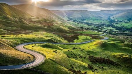 Curvy Road Through Majestic Green Hills wallpaper