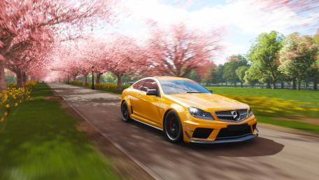 Bold Yellow Dream Car Amidst Cherry Blossoms wallpaper