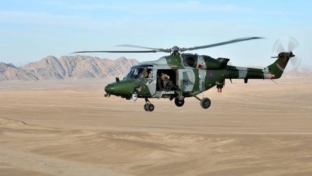 Military Helicopter in Action Over Desert Landscape wallpaper