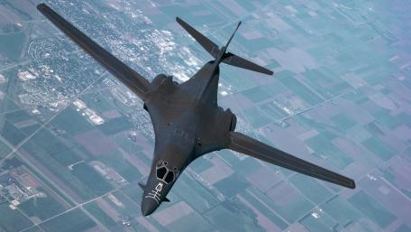 Stealth Bomber in Flight Over Landscape wallpaper