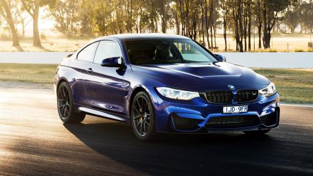 Sleek BMW Driving Through Sunlit Landscape wallpaper