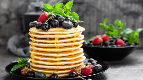 Delicious Stack of Fluffy Pancakes with Berries and Mint wallpaper