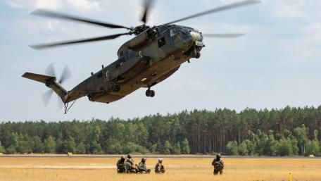 Powerful Helicopter in Action Above Troops on the Ground wallpaper