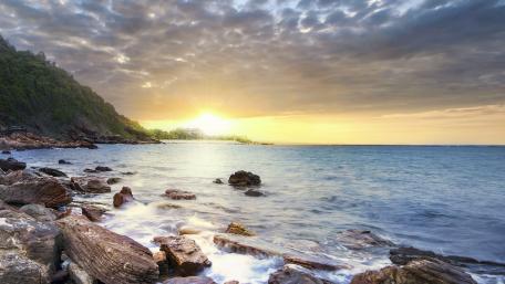 Tranquil Sea Sunset Over Rocky Shoreline wallpaper
