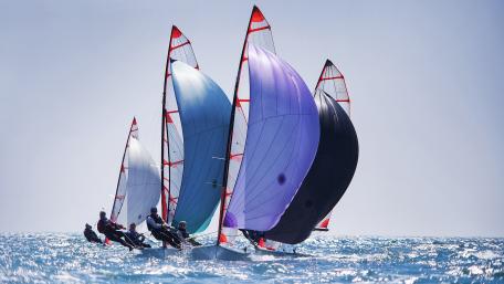 Dynamic Sailboats Racing Across Crystal Blue Waters wallpaper
