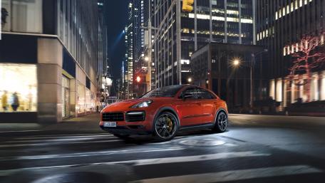 Sleek Car in Night Cityscape Wallpaper wallpaper