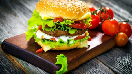 Deliciously Stacked Hamburger on Wooden Platter wallpaper