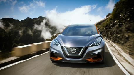 Sleek Nissan Driving Through Scenic Landscape wallpaper