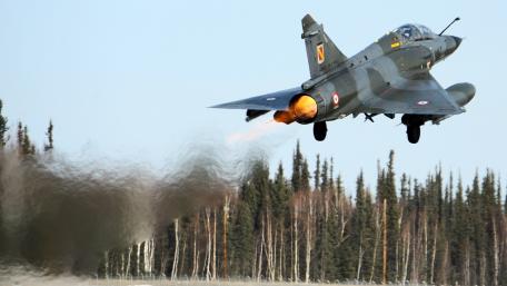 Majestic Jet in Action Over Breathtaking Landscape wallpaper