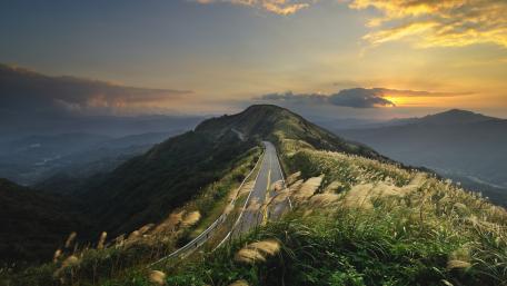 Winding Road Through Majestic Mountains wallpaper
