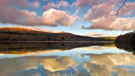 Serene Lake Reflection Under Fluffy Clouds wallpaper