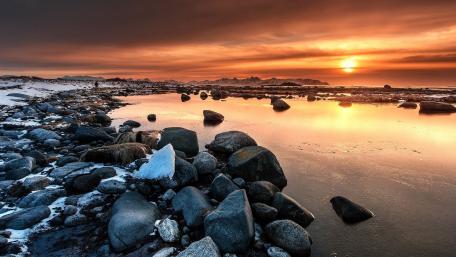 Serene Sunset Over Rocky Shoreline wallpaper