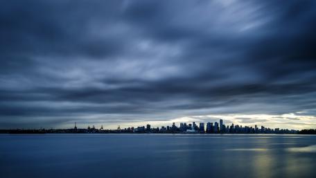 Moody City Skyline Under Cloudy Skies wallpaper