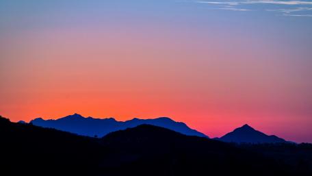 Mountain Silhouettes Against Pink Sunset Sky wallpaper
