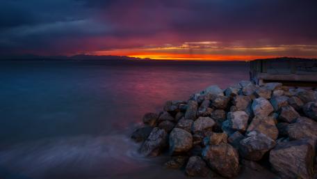 Serene Sunset Over Rocky Shoreline wallpaper