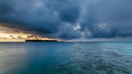 Tranquil Island Escape Under Dramatic Skies wallpaper