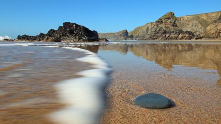 Serene Shoreline Blissful Waves and Rocky Coastline wallpaper