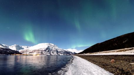 Enchanting Aurora Borealis Over Snowy Mountains wallpaper