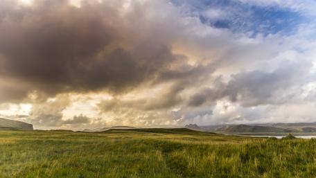 Serene Cloudy Landscape Over Lush Grassland wallpaper
