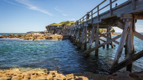 Serene Coastal Footbridge Over Crystal Clear Waters wallpaper