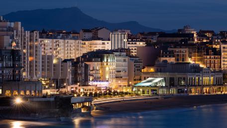 City Lights Reflecting on the Ocean at Dusk wallpaper