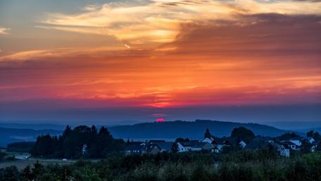 Majestic Sunset Over a Tranquil Village wallpaper