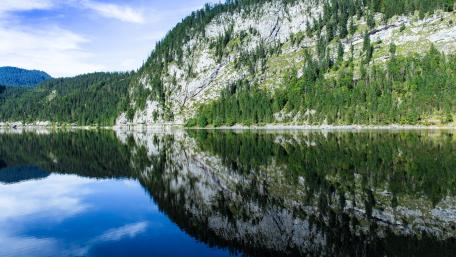 Serene Lake Reflection Amidst Majestic Mountains wallpaper