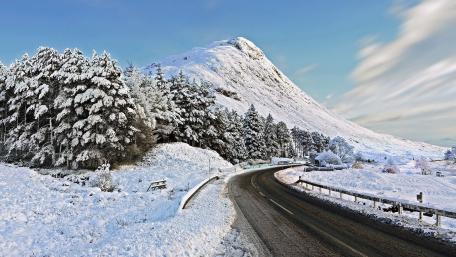 Serene Winter Road Through Snowy Mountains wallpaper